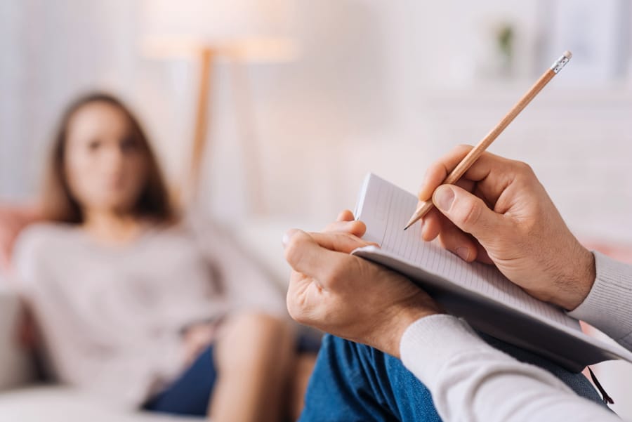 therapist taking notes during session with female client